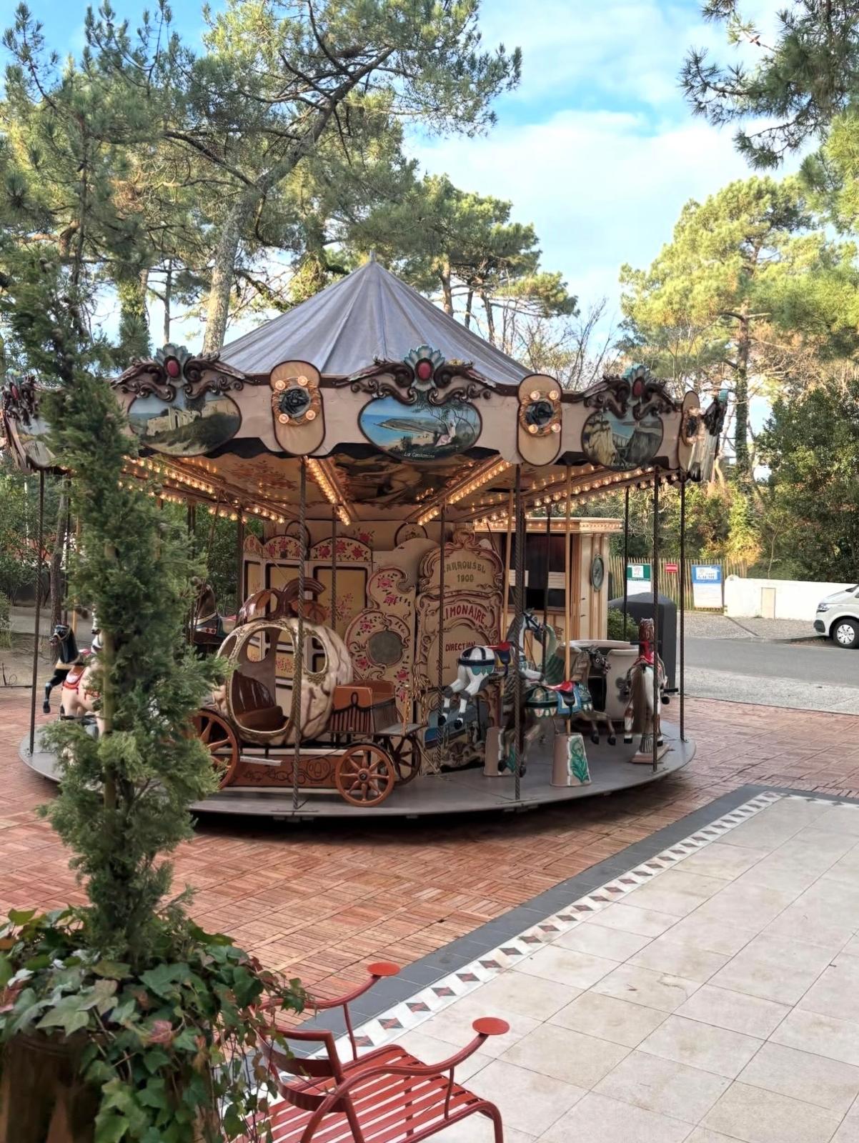 Carrousel 1900 en bois décoré de fresques peintes à la main