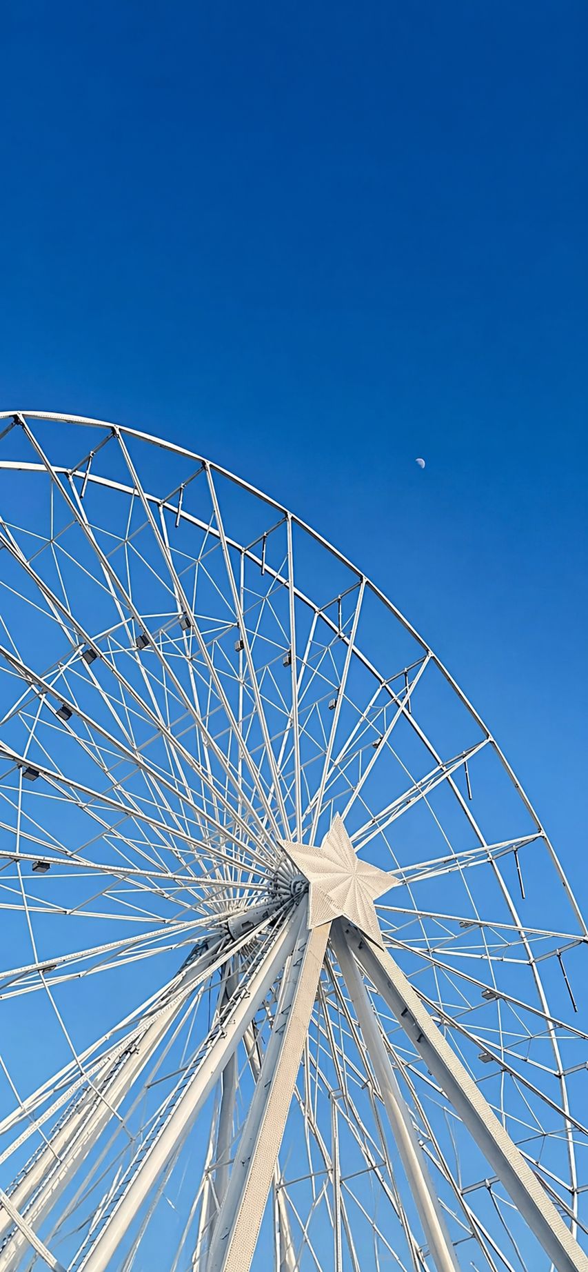 Grande roue de 50m vue en contre-plongée avec étoile et ciel bleu