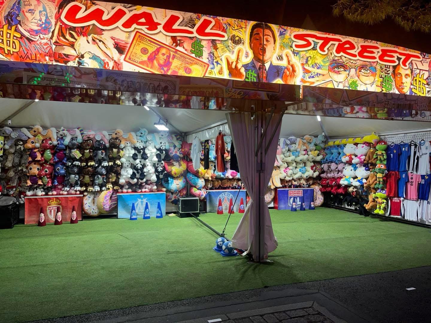 Stand Wall Street illuminé de nuit avec peluches et maillots